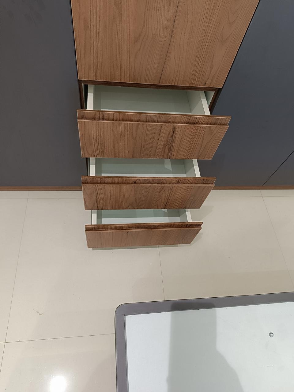 Wardrobe drawer stack in a warm wood finish with three pull-out drawers