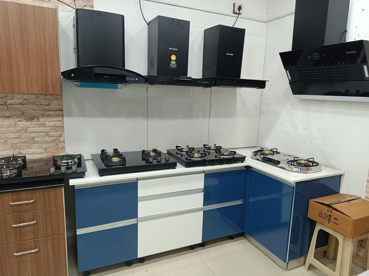Modular kitchen in blue and white gloss with a black chimney hood