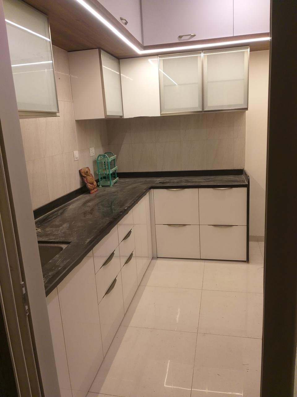 U-shaped modular kitchen in white with frosted-glass wall cabinets