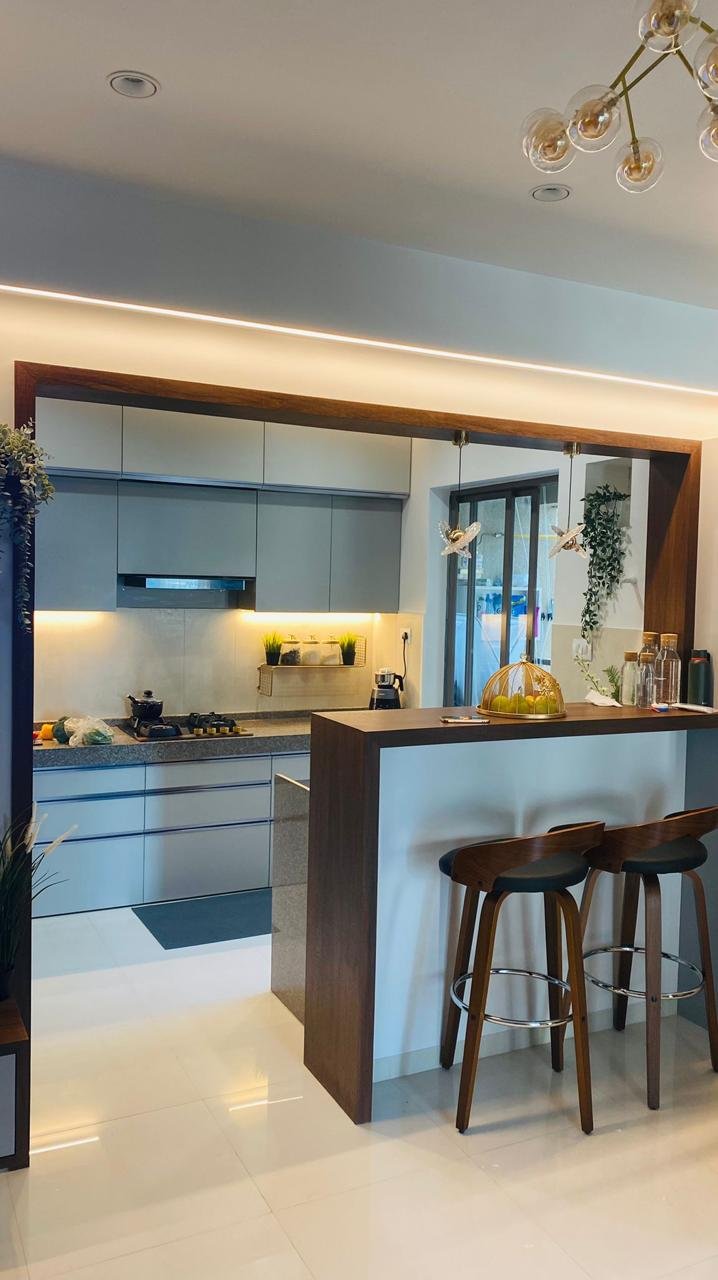 Open modular kitchen in grey with a walnut breakfast bar and counter seating