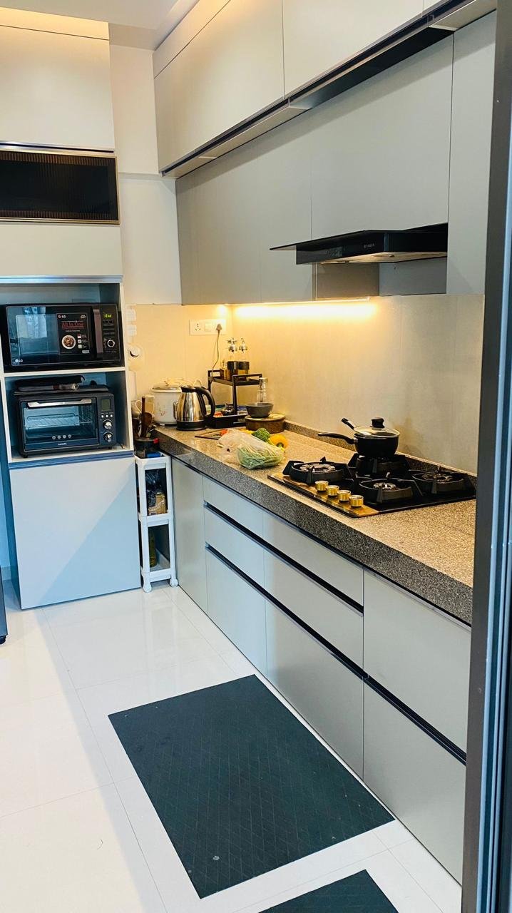 Modular kitchen in matte grey with a granite countertop and under-cabinet lighting