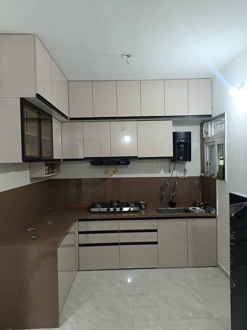 U-shaped modular kitchen in beige PU finish with a brown backsplash
