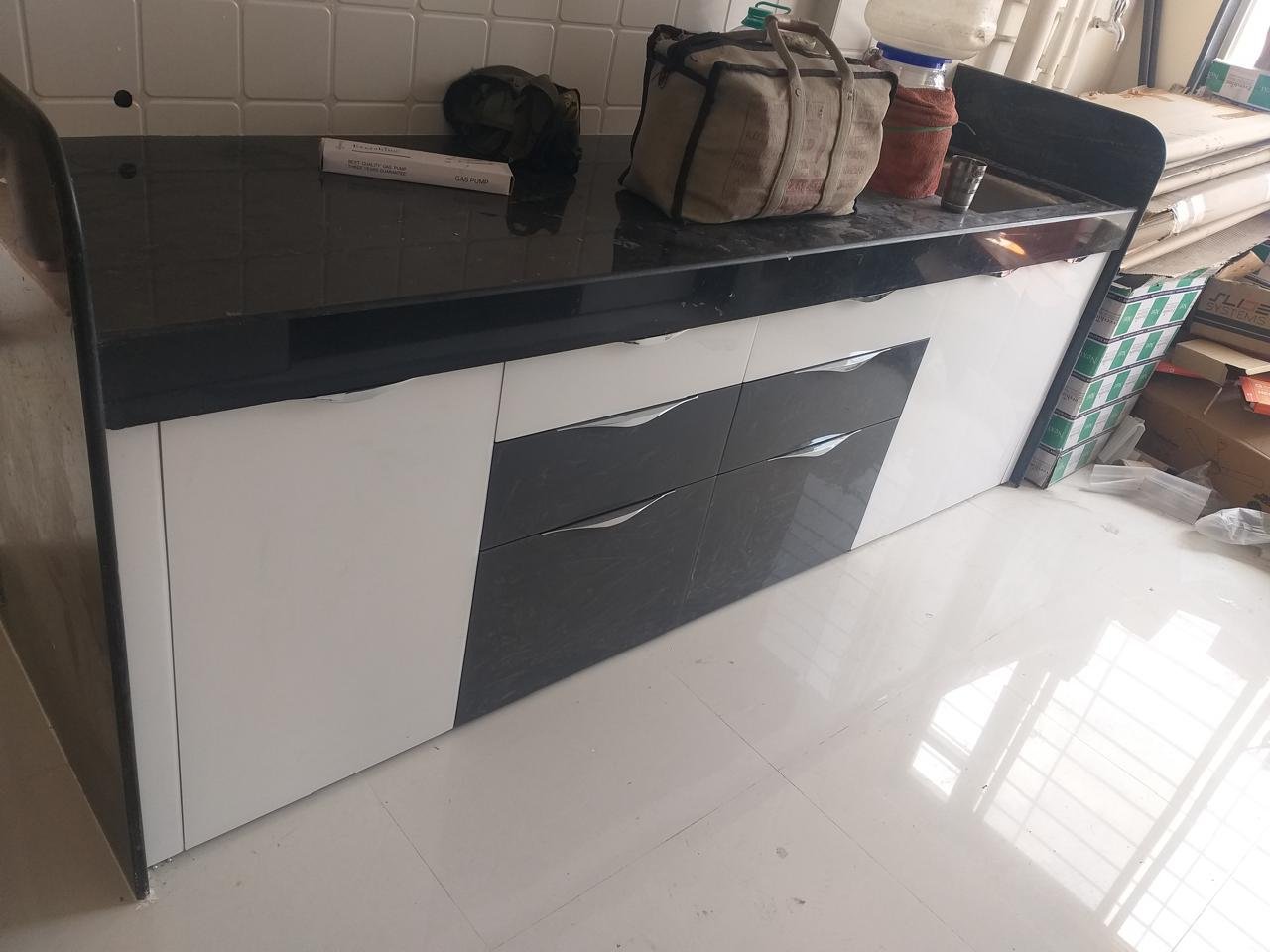 Modular kitchen in white and black gloss with a black granite countertop